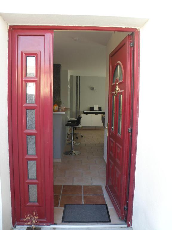 une porte rouge menant à une chambre avec une cuisine dans l'établissement Appartement proche Centre Ville avec PARKING PRIVE, à Avignon