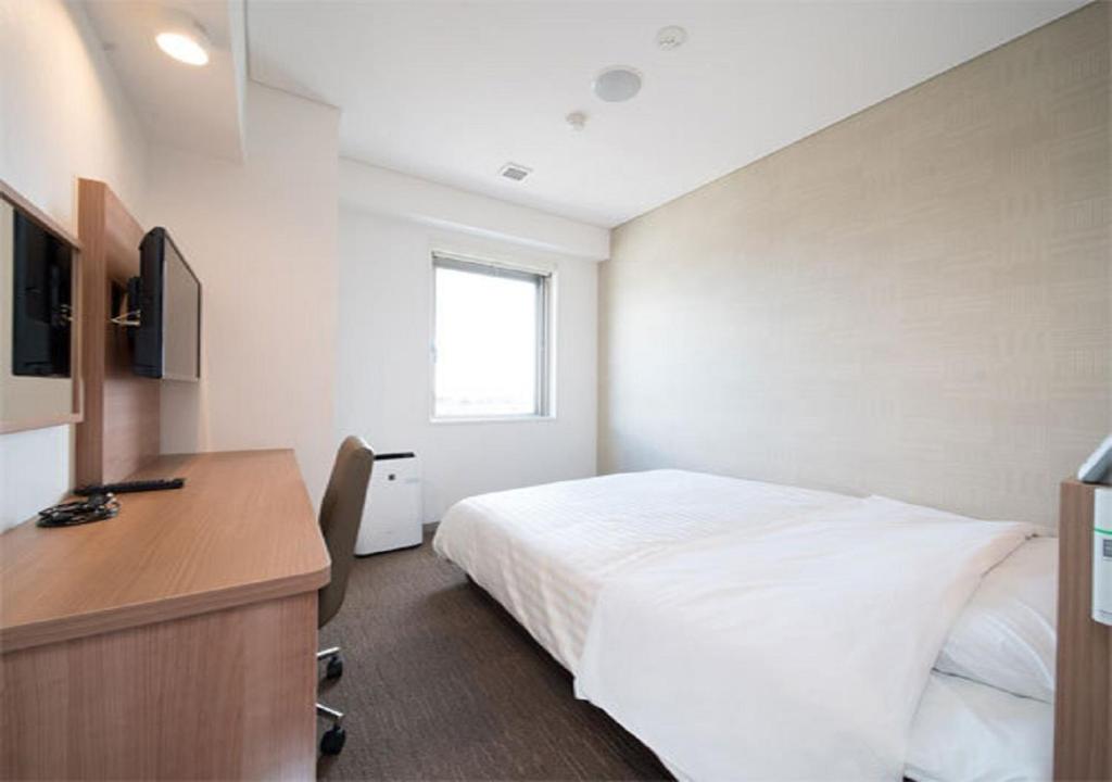 a bedroom with a bed and a desk and a television at Iwaki - Hotel / Vacation STAY 22823 in Iwaki