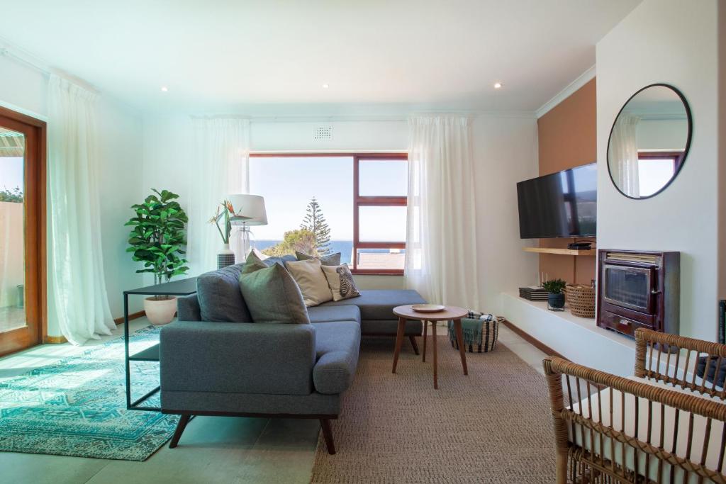 a living room with a couch and a table at Seascape Cottage in Cape Town