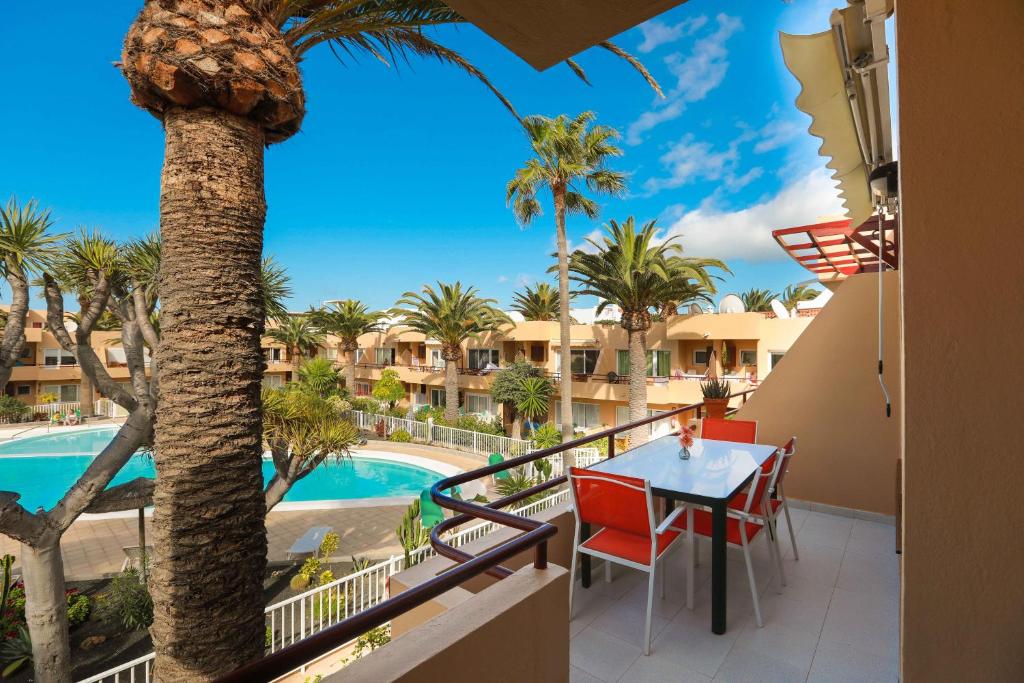 a balcony with a table and chairs and a pool at Luxury Cayetana, by Comfortable Luxury in Corralejo