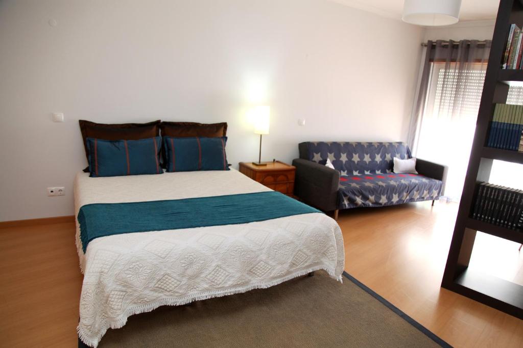 um quarto com uma cama grande e um sofá em 20 da Vila - Apartment with Terrace em São Bartolomeu de Messines