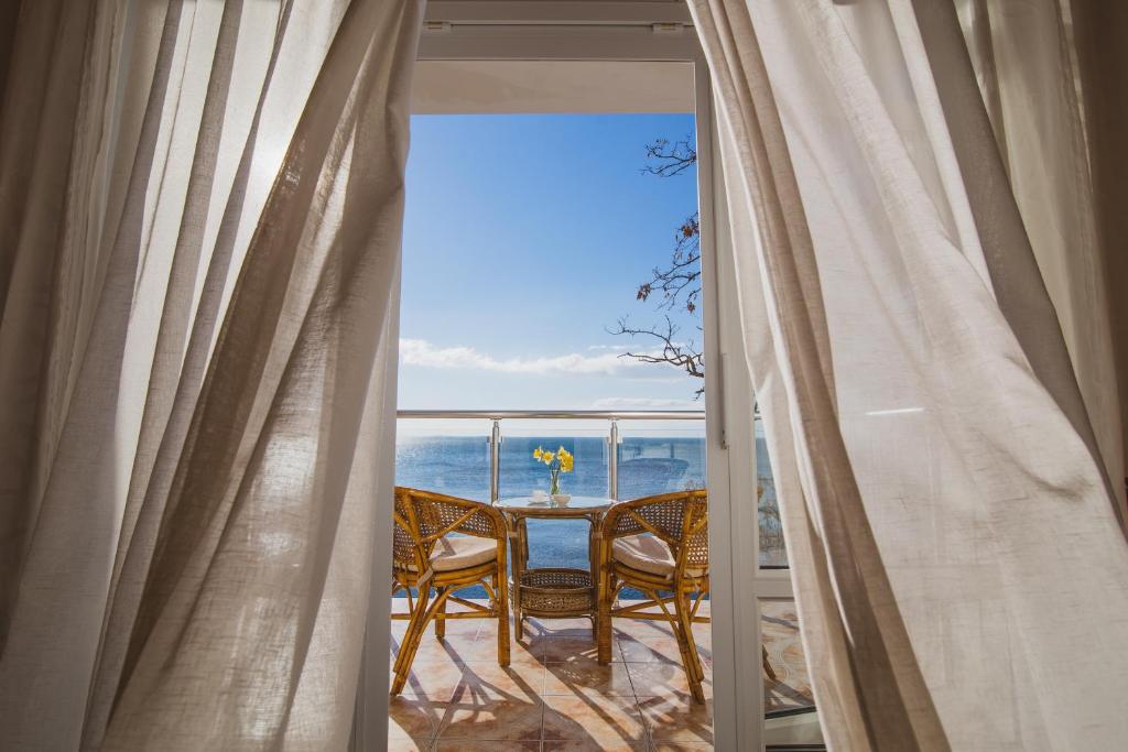 una vista dal balcone di una camera con tavolo e sedie di Hotel Coral Yalta a Jalta