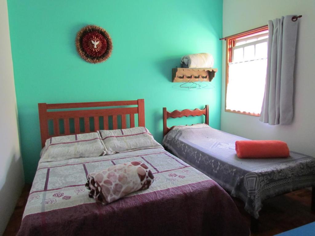 dos camas sentadas una al lado de la otra en un dormitorio en Hostel Lumiar da Serra, en Tiradentes