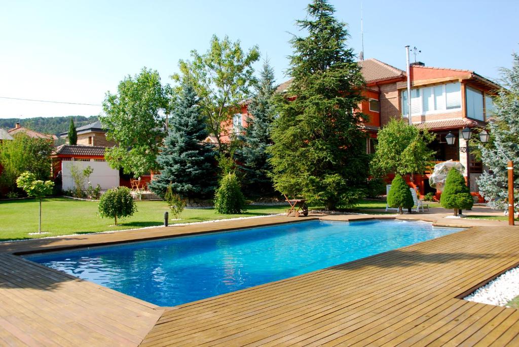 a swimming pool in front of a house at B&B Concha in Becerril de la Sierra