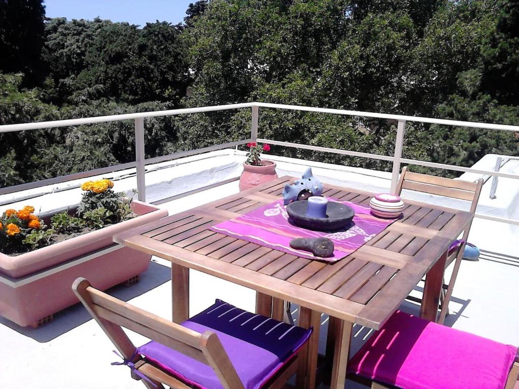 - une table et des chaises en bois au-dessus d'une terrasse dans l'établissement Park House -beside the Medieval Town of Rhodes, à Rhodes