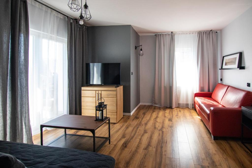a living room with a couch and a flat screen tv at 5 Wierchów Apartamenty in Bukowina Tatrzańska