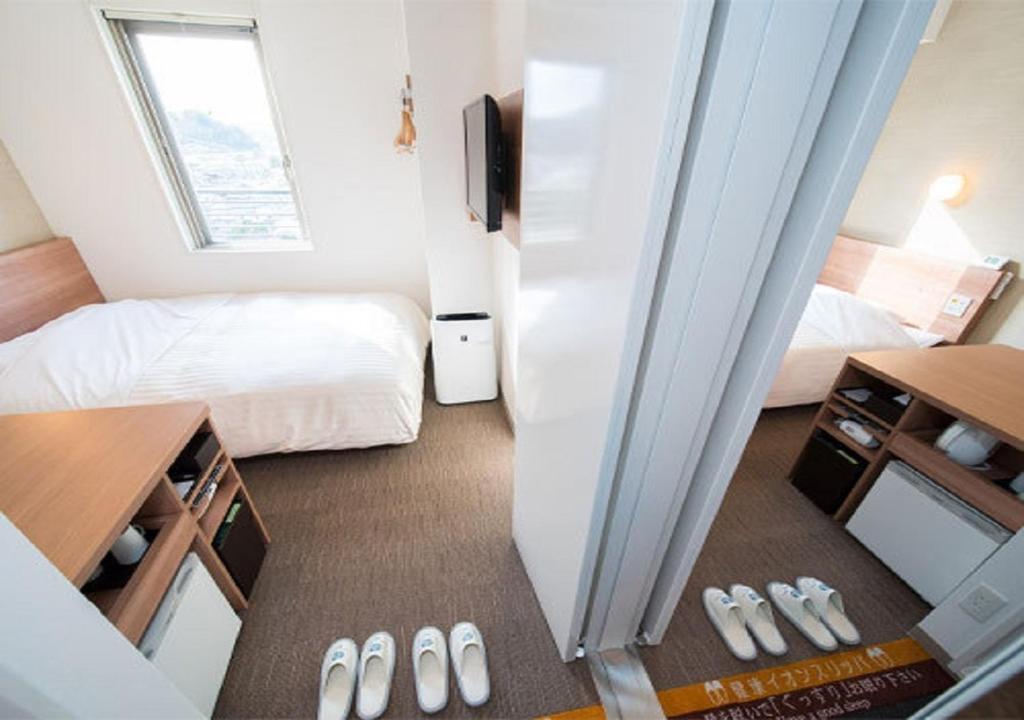 いわき市にあるIwaki - Hotel / Vacation STAY 22985のベッド1台とベッドルームへのドアが備わる小さな客室です。