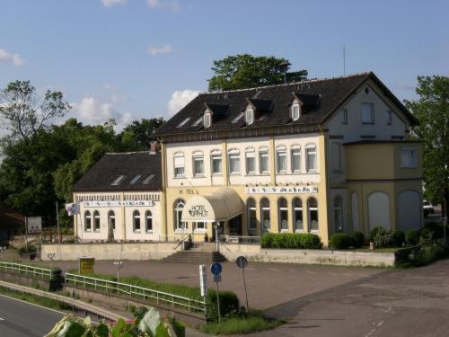 ein großes gelbes und weißes Gebäude an der Straßenseite in der Unterkunft Hotel Kipphut in Sarstedt