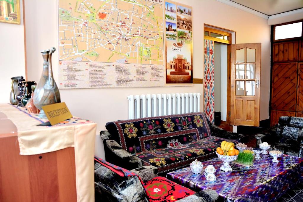 a living room with a couch and a table at Nurobod Guesthouse in Bukhara