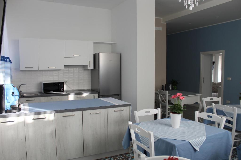 une cuisine avec des placards blancs et une table avec un chiffon bleu dans l'établissement IL GIARDINO DEI GLICINI, à Ercolano