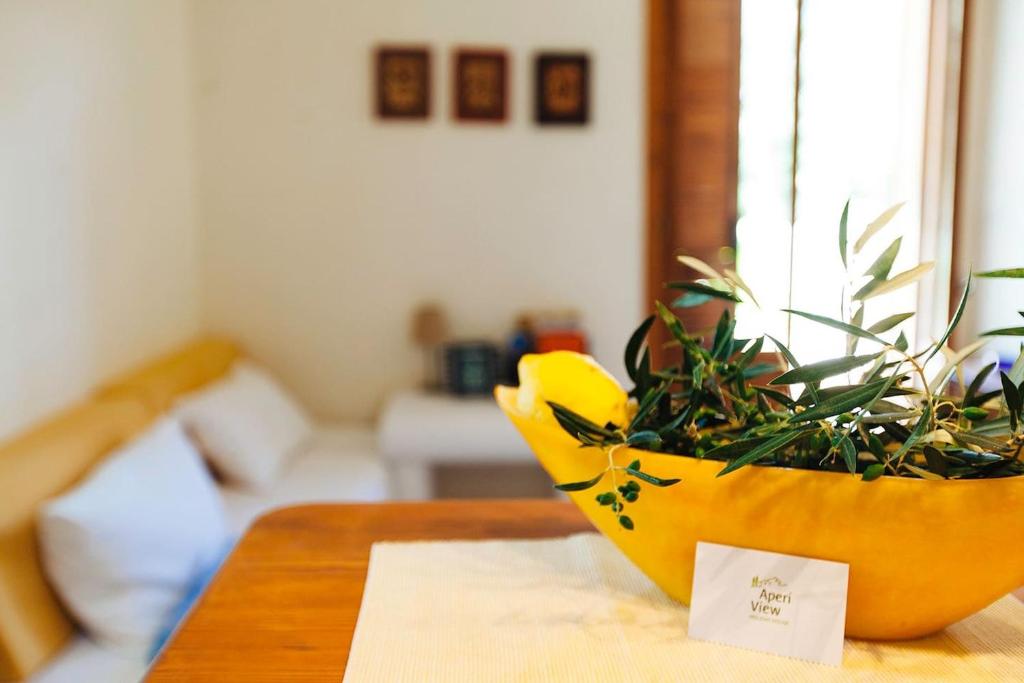 a yellow planter sitting on a table with a plant at Aperi View in Karpathos