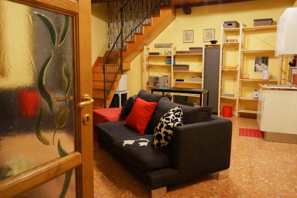sala de estar con sofá y escalera en Casa Pace, en Vetralla