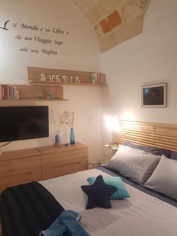a bedroom with a bed with a tv on the wall at Namastè in Polignano a Mare