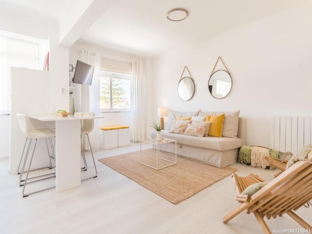 a white living room with a couch and a table at Parede Ocean in Parede