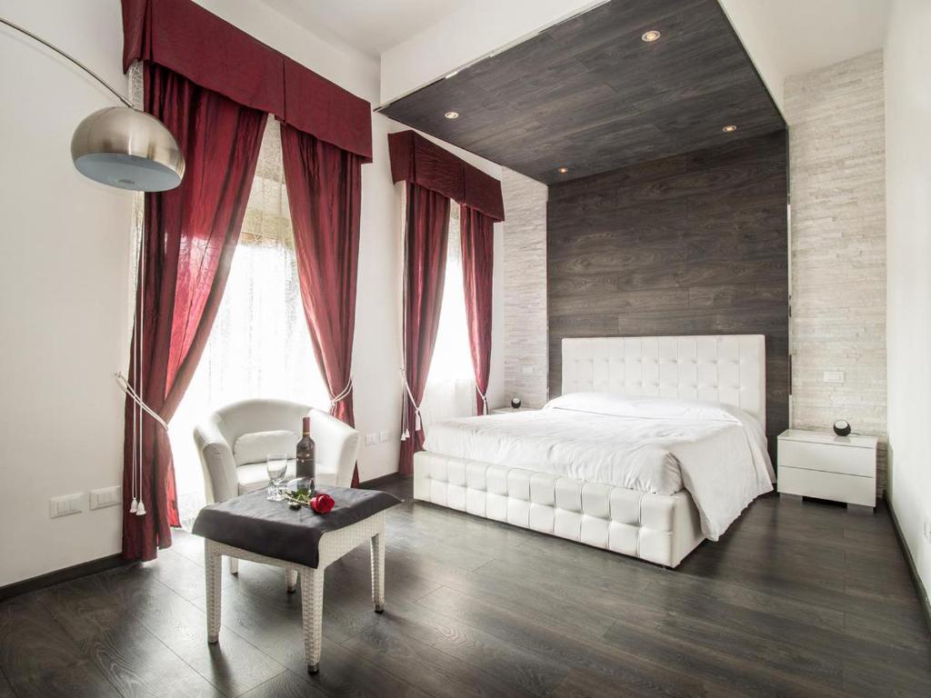 ローマにあるロイヤル ルームズのベッドルーム(白いベッド1台、赤いカーテン付)