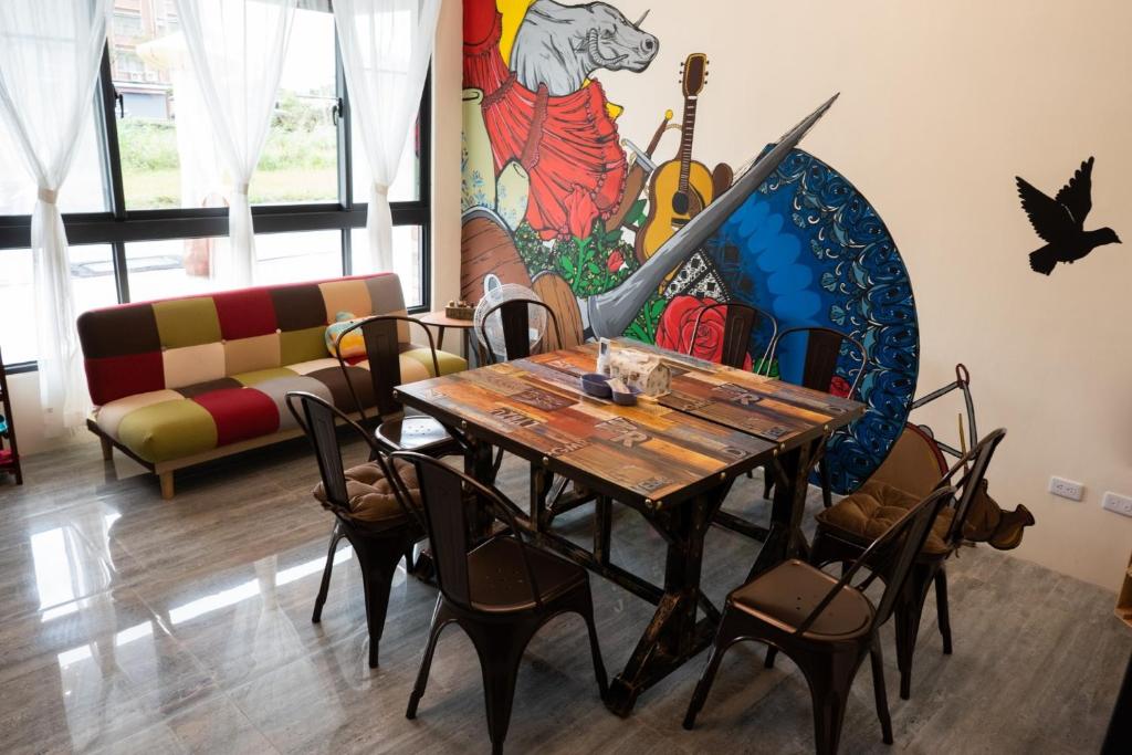 a dining room with a table and chairs and a mural at POSADA in Taitung City