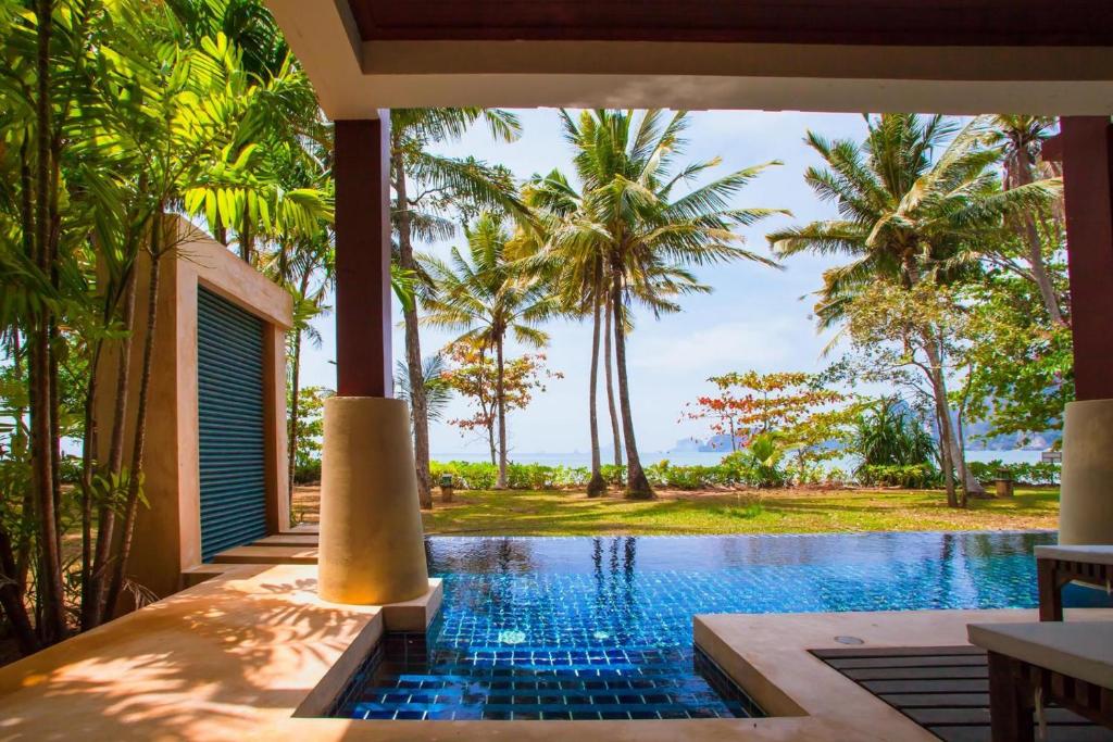 a view of a pool from a house with palm trees at Amatapura Beach Villa 6 in Ao Nam Mao