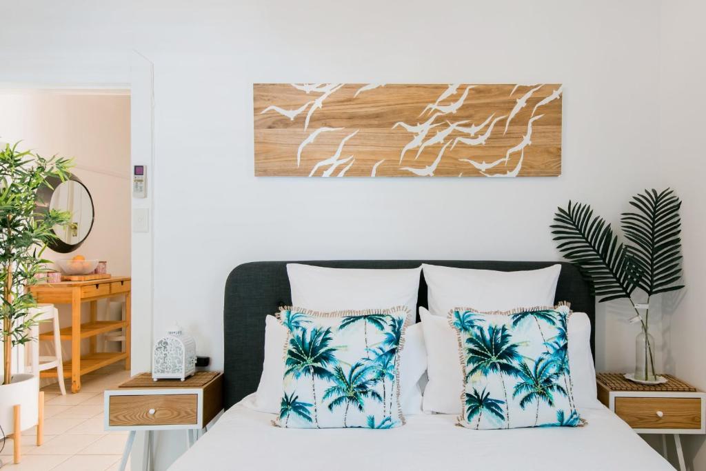 een slaapkamer met een bed met blauwe en witte kussens bij HolidayRento The Palm House Bondi in Sydney