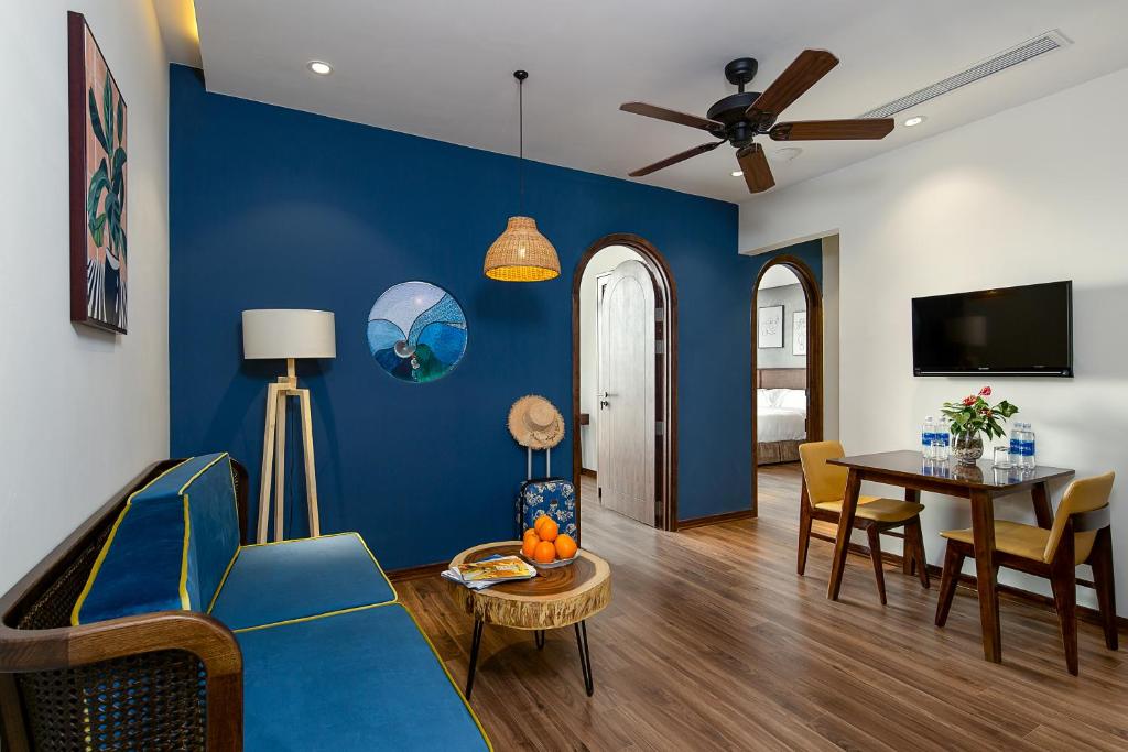 een woonkamer met een blauwe muur bij Tropical House Apartment Da Nang in Da Nang