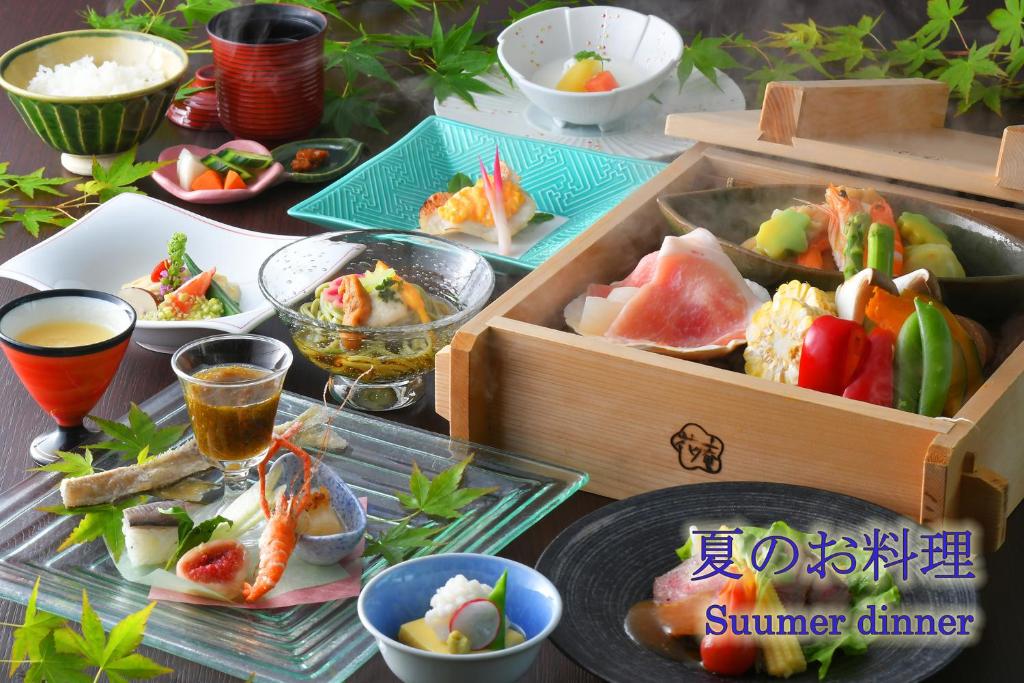 a table topped with plates of food and bowls of food at Hotel Hanaan in Nikko