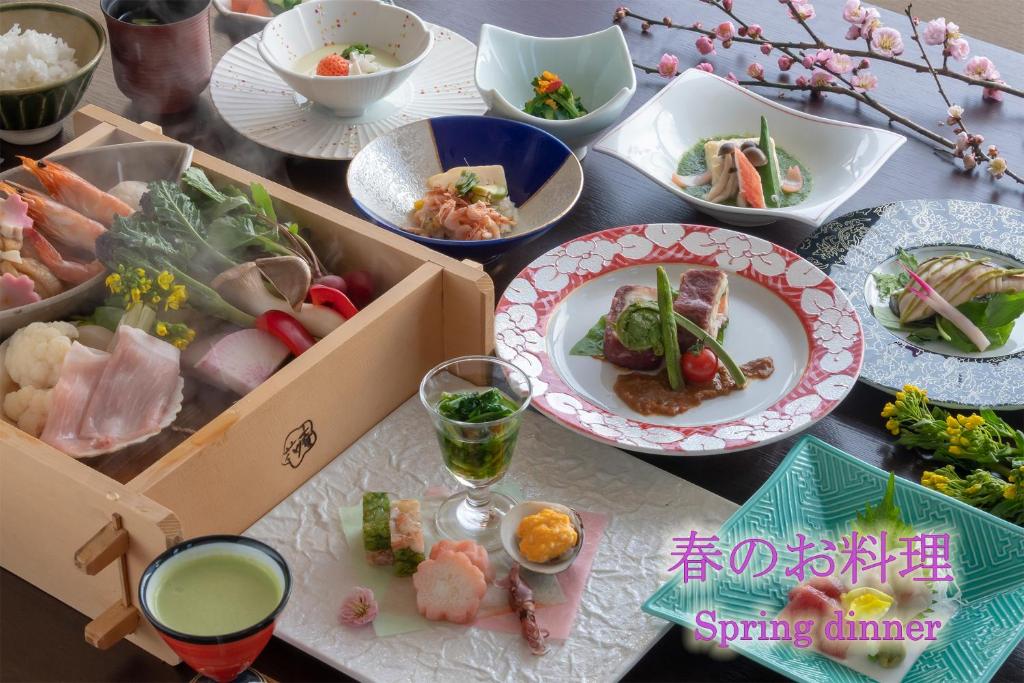a table with many plates of food on it at Hotel Hanaan in Nikko