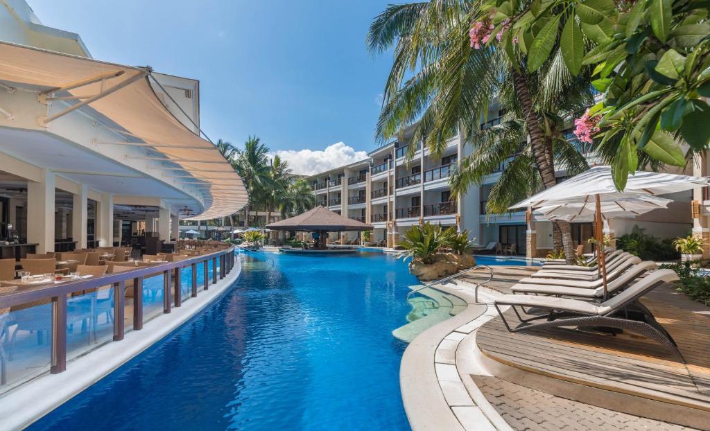 a swimming pool with lounge chairs and a resort at Henann Lagoon Resort in Boracay