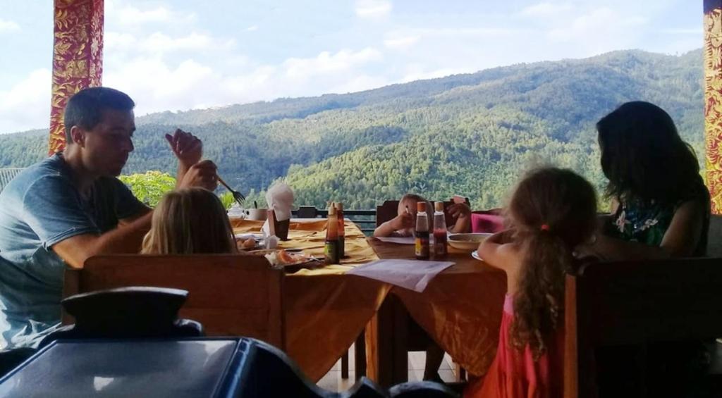 een groep mensen aan een tafel in een restaurant bij Aris Homestay and Warung Made in Munduk