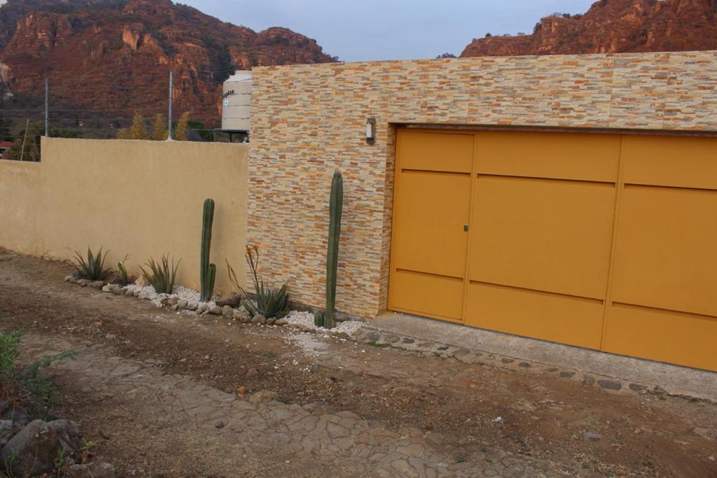 a garage with yellow doors on the side of a building at Casa El Camino in Amatlán