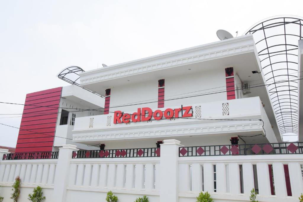 a white building with a redboard sign on it at RedDoorz near UIN Sumatera Utara in Medan