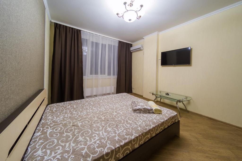 um quarto de hotel com uma cama e uma televisão em Kvartirkoff na Bogatirskaya 6a, 2 floor em Kiev