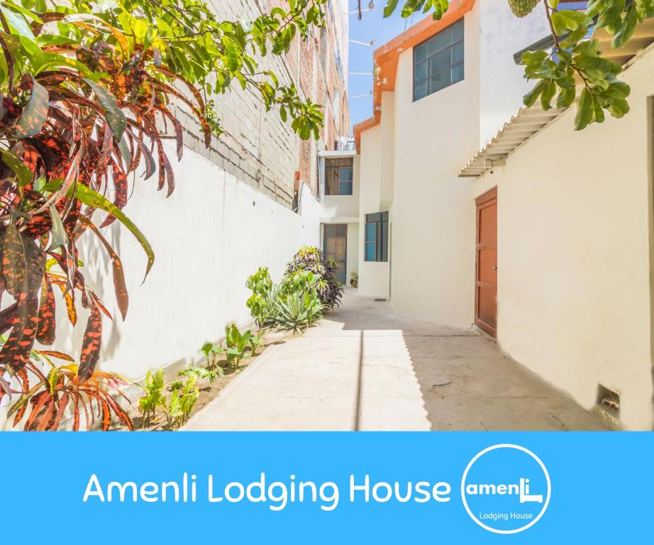 ein Apartmenthaus mit einer Straße, die zu einem Haus führt in der Unterkunft Amenli Lodging House in Piura