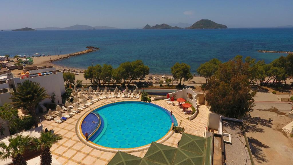 una vista aérea de una piscina y el océano en Yelken Mandalinci Spa&Wellness Hotel, en Turgutreis