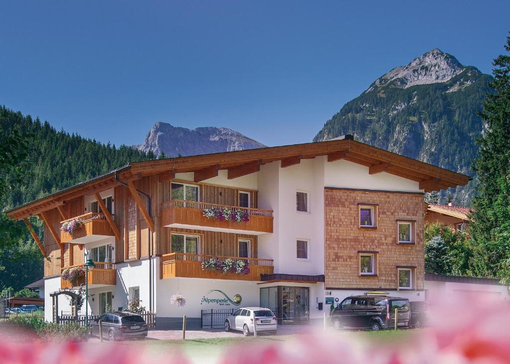 a large building with cars parked in front of it at Alphaus Aparthotel in Pertisau