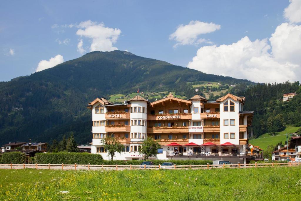 ein großes Hotel mit einem Berg im Hintergrund in der Unterkunft Hotel Riedl im Zillertal in Stumm