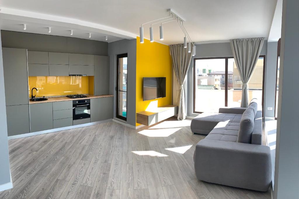 a living room with a couch and a kitchen at Brand new luxurios loft by the sea in Mamaia Nord