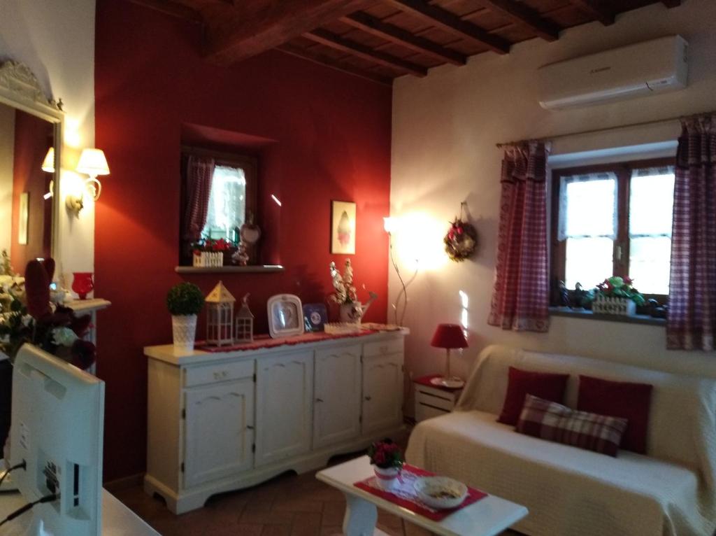 ein Wohnzimmer mit roten Wänden und einem Sofa in der Unterkunft Suite "La Badia" in Scandicci