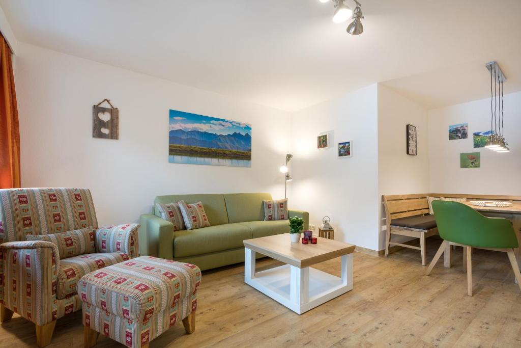 ein Wohnzimmer mit einem Sofa und einem Tisch in der Unterkunft Ferienwohnungen Alpentraum - Mäusle in Oberstdorf