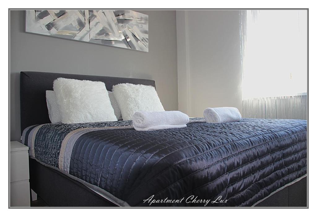 a bedroom with a bed with two towels on it at Apartment Cherry Lux in Zrenjanin