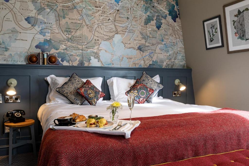 a bed with a tray of food on it at The Brook Green Hotel in London