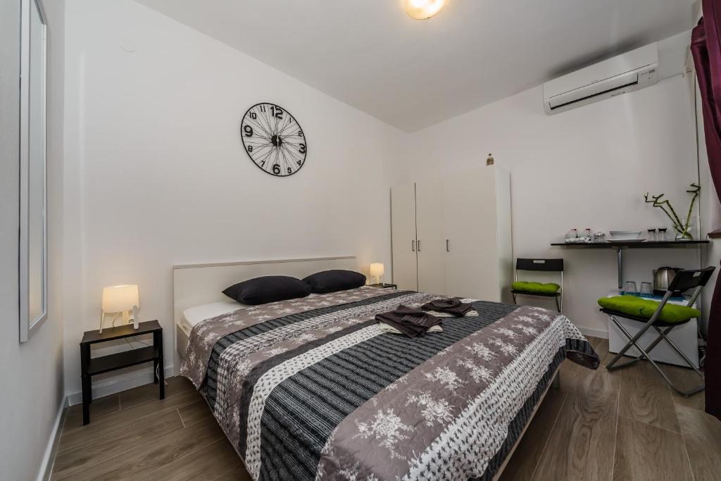 a bedroom with a bed with a clock on the wall at Room Mar in Vis