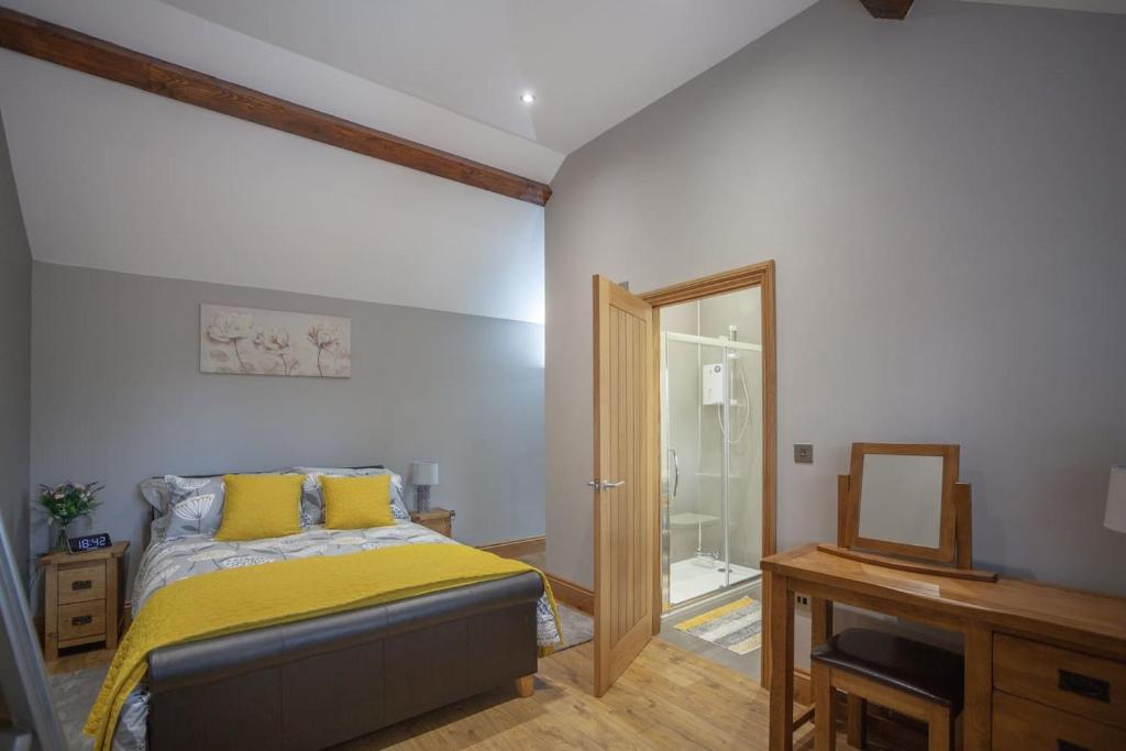 um quarto com uma cama com lençóis amarelos e um espelho em Little Oak by RentMyHouse em Hereford