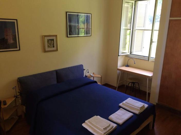 Un dormitorio con una cama azul con toallas. en Queen bedroom, en Terracina