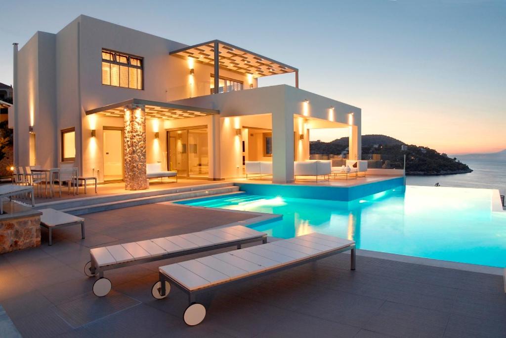 une maison avec une piscine en face de l'océan dans l'établissement Villa Soligia, à Pefkali