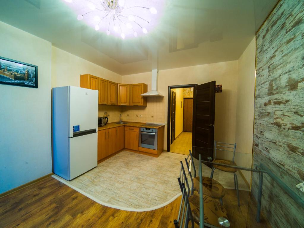 a kitchen with a refrigerator and wooden cabinets at Kvartirkoff na Petra Kalnyshevsky 7, 26 floor in Kyiv