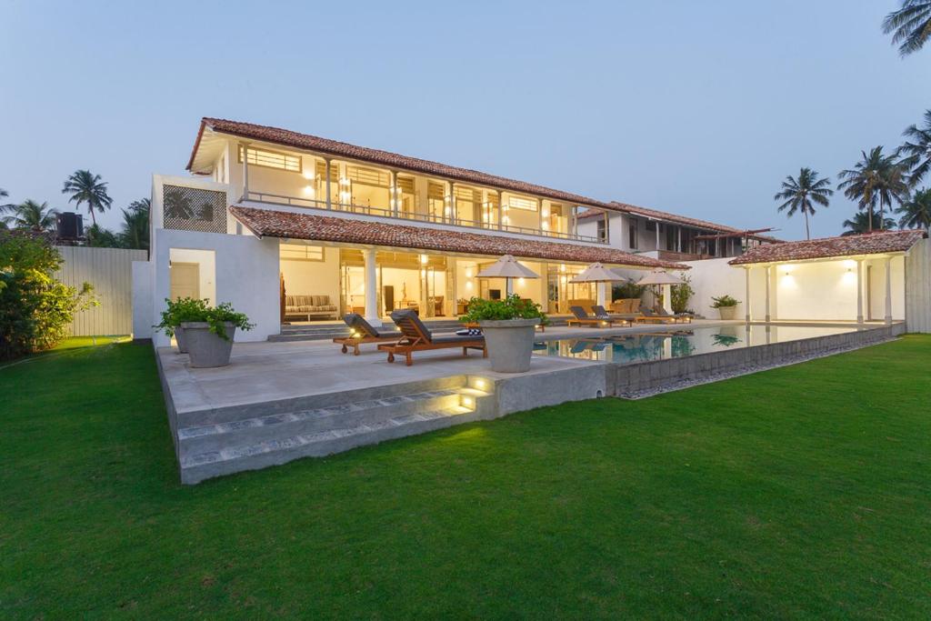 a large house with a swimming pool in a yard at Villa Ahasa in Belikolapagoda