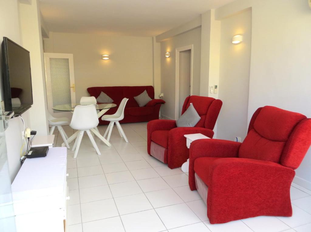 ハベアにある2 bedroom apartment L'Ancora in the Arenal Beachのリビングルーム(赤い椅子、テレビ付)