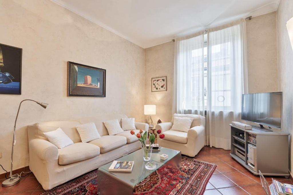 ein Wohnzimmer mit einem Sofa und einem TV in der Unterkunft Arsenale Art Apartment in Turin