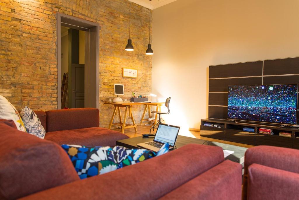 uma sala de estar com um sofá e uma televisão em SummerStreetSeven em Budapeste