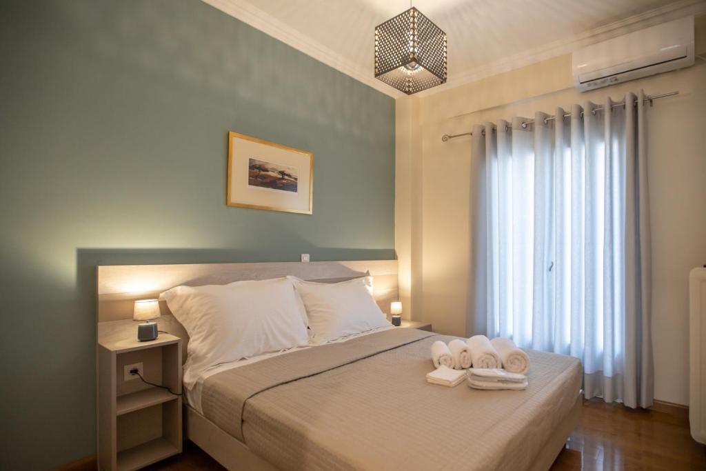 a bedroom with a bed with two towels on it at PARADISE APARTMENT IN PIRAEUS CENTRE in Piraeus