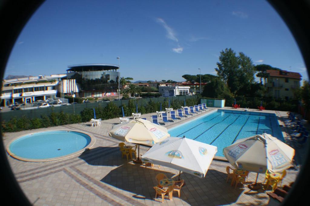 una piscina con sombrillas y sillas y una piscina en Camping Versilia Mare, en Lido di Camaiore